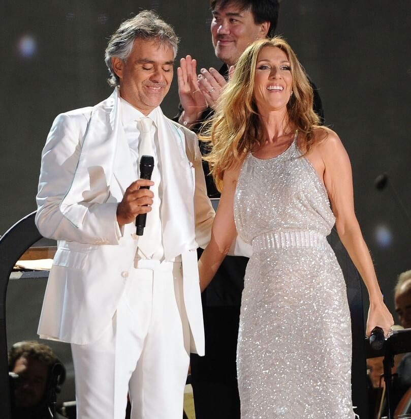 Andrea Bocelli, resplendent in a crisp white suit, awaits a special guest on stage. Suddenly, Celine Dion emerges in a sparkling silver dress. Together, they deliver a history-making rendition of “The Prayer,” now the most-watched version with over 198 million views.